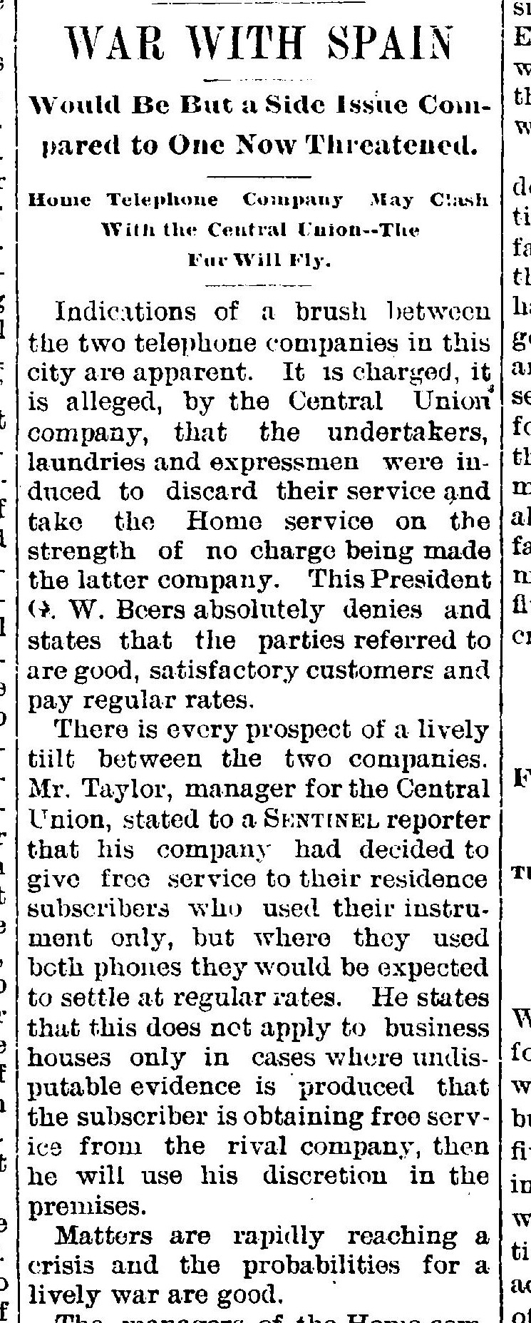 A newspaper column headed WAR WITH SPAIN, with smaller lines reading Would Be But a Side Issue Compared to One Now Threatened, and Home Telephone Company May Clash With the Central Union, The Fur Will Fly, above a report of a brush between the two telephone companies in the city.